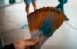 person holding brown, blue, and white tickets
