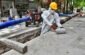 a man wearing a protective suit and a hard hat working on a street