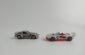 two toy cars sitting side by side on a white surface