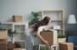 a woman moving boxes in a living room